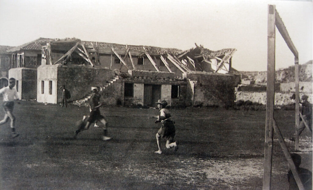 Ποδόσφαιρο στο κάστρο. Έτος λήψης 1935 ή 1936. Στο βάθος διακρίνονται τα δίδυμα κτίσματα – στρατώνες της Αγγλοκρατίας.